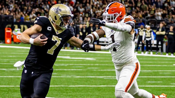 Taysom Hill (7) of the New Orleans Saints runs through  Cleveland Browns safety Juan Thornhill (1)