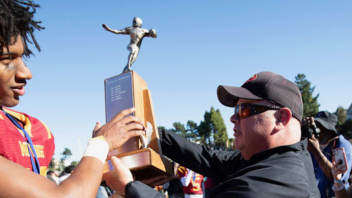 Lincoln football coach Phil Ferrigno (right) hands off one of the school's 10 San Francisco Section championship trophies from 2005 to 2023 with him as head coach. This was after 35-0 win over Balboa in the 2023 title game at Kezar Stadium.
