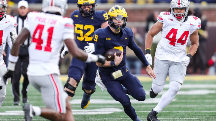 Michigan quarterback J.J. McCarthy runs past Ohio State defensive end JT Tuimoloau (44) during the second half at Michigan Stadium in Ann Arbor on Saturday, Nov. 25, 2023.