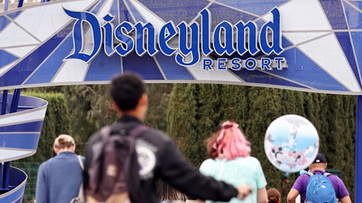 ANAHEIM, CALIFORNIA – APRIL 24: People walk toward an entrance to Disneyland on April 24, 2023 in Anaheim, California. Disney will lay off several tho