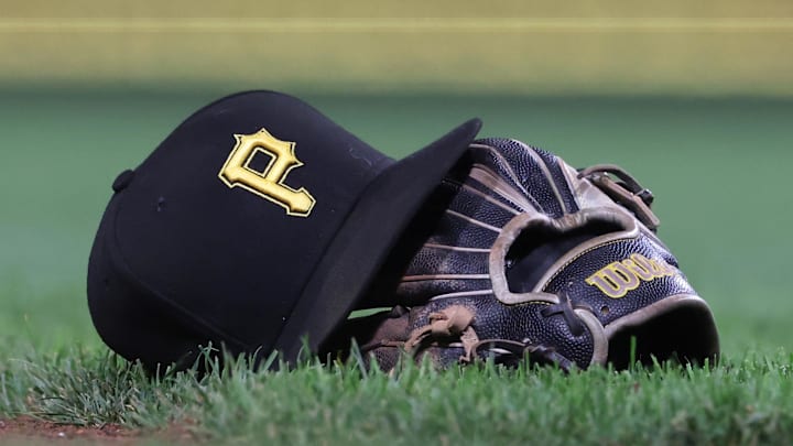Sep 16, 2025; Pittsburgh, Pennsylvania, USA; A hat and glove belonging to Pittsburgh Pirates third baseman Jared Triolo (not pictured) on the field against the Chicago Cubs during the sixth inning at PNC Park. Mandatory Credit: Charles LeClaire-Imagn Images