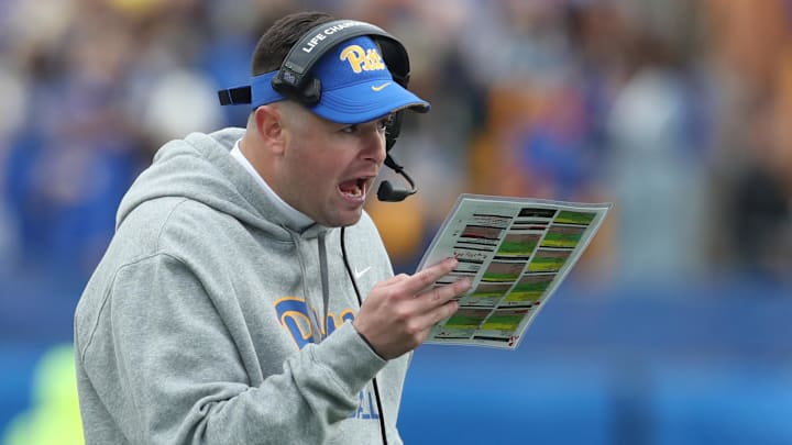 Nov 16, 2024; Pittsburgh, Pennsylvania, USA;  Pittsburgh Panthers offensive coordinator Cade Bell looks over his play chart against the Clemson Tigers during the fourth quarter at Acrisure Stadium. Mandatory Credit: Charles LeClaire-Imagn Images