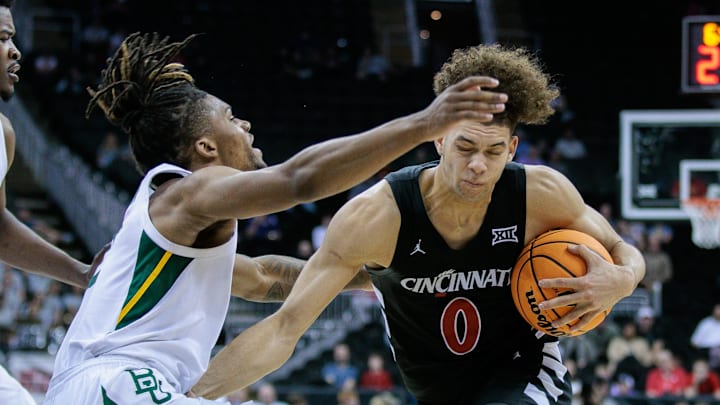 Mar 14, 2024; Kansas City, MO, USA; Cincinnati Bearcats guard Dan Skillings Jr. (0) drives past Baylor Bears guard Jayden Nunn (2) during the second half at T-Mobile Center. Mandatory Credit: William Purnell-Imagn Images Mar 14, 2024; Kansas City, MO, USA; Cincinnati Bearcats guard Dan Skillings Jr. (0) drives past Baylor Bears guard Jayden Nunn (2) during the second half at T-Mobile Center. Mandatory Credit: William Purnell-Imagn Images