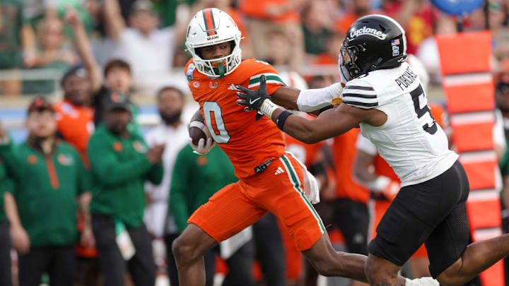 Dec 28, 2024; Orlando, FL, USA; Miami Hurricanes wide receiver Joshisa Trader (0) holds off Iowa State Cyclones defensive back Myles Purchase (5) in the second quarter during the Pop Tarts bowl at Camping World Stadium. Mandatory Credit: Nathan Ray Seebeck-Imagn Images