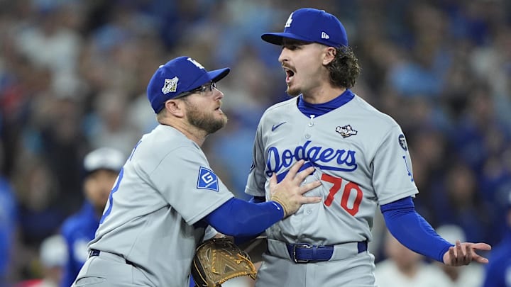 Los Angeles Dodgers third baseman Max Muncy (13) and pitcher Justin Wrobleski (70) react after Toronto Blue Jays shortstop Andres Gimenez (0) is hit by a pitch in the fourth inning during game seven of the 2025 MLB World Series at Rogers Centre on Saturday.