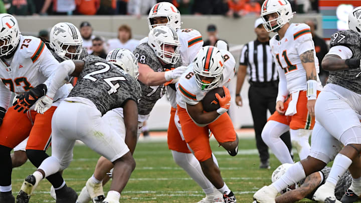 Nov 22, 2025; Blacksburg, Virginia, USA;  Miami (FL) Hurricanes running back Charmar Brown (6) runs the ball as Virginia Tech Hokies linebacker Jaden Keller (24) defends at Lane Stadium. Mandatory Credit: Brian Bishop-Imagn Images