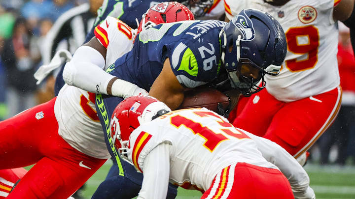 Aug 15, 2025; Seattle, Washington, USA; Seattle Seahawks running back Zach Charbonnet (26) rushes against the Kansas City Chiefs during the first quarter at Lumen Field.