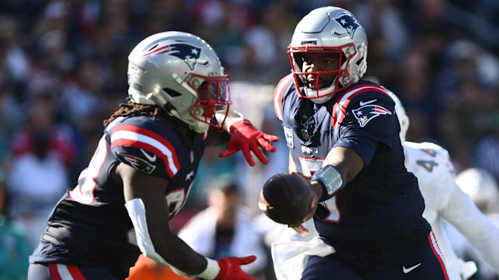 Oct 6, 2024; Foxborough, Massachusetts, USA; New England Patriots quarterback Jacoby Brissett (7) hands the ball off to running back Rhamondre Stevenson (38) during the second half at Gillette Stadium. Mandatory Credit: Brian Fluharty-Imagn Images