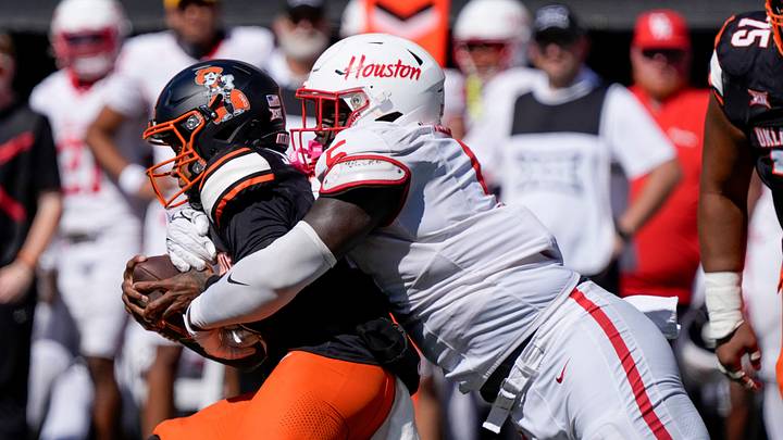 Houston Cougars defensive lineman Carlos Allen (5) brings down Oklahoma State Cowboys quarterback Sam Jackson V (18) during a college football game between the Oklahoma State Cowboys (OSU) and the Houston Cougars at Boone Pickens Stadium in Stillwater, Okla., Saturday, Oct. 11, 2025. Houston won 39-17. Houston Cougars defensive lineman Carlos Allen (5) brings down Oklahoma State Cowboys quarterback Sam Jackson V (18) during a college football game between the Oklahoma State Cowboys (OSU) and the Houston Cougars at Boone Pickens Stadium in Stillwater, Okla., Saturday, Oct. 11, 2025. Houston won 39-17.
