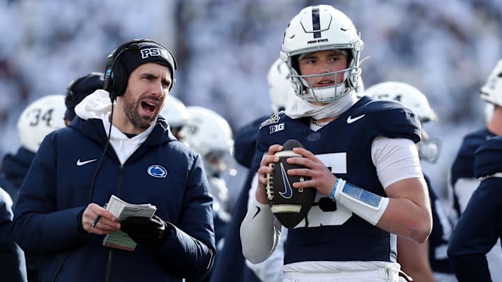 Penn State Nittany Lions quarterback Drew Allar (15) warms up on the sideline while listening to quarterback coach Danny O'Brien (left) during the first quarter against the SMU Mustangs in the first round of the College Football Playoff at Beaver Stadium. Penn State Nittany Lions quarterback Drew Allar (15) warms up on the sideline while listening to quarterback coach Danny O'Brien (left) during the first quarter against the SMU Mustangs in the first round of the College Football Playoff at Beaver Stadium.