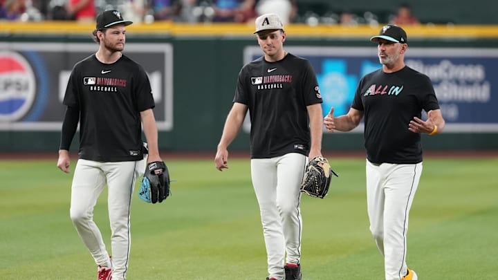 May 17, 2025; Phoenix, Arizona, USA;  Arizona Diamondbacks manager Torey Lovullo (17), pitcher Brandon Pfaadt (32) and pitcher Ryne Nelson (19) talk during warmups before a game against the Colorado Rockies at Chase Field. Mandatory Credit: Jacob Reiner-Imagn Images