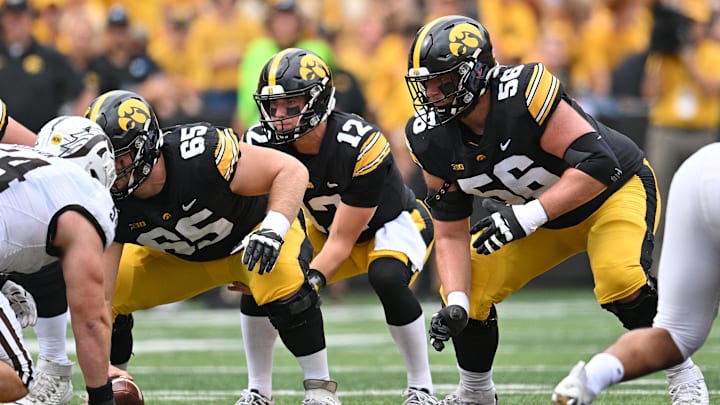 Sep 16, 2023; Iowa City, Iowa, USA; Iowa Hawkeyes quarterback Cade McNamara (12), offensive lineman Logan Jones (65) and offensive lineman Nick DeJong (56) prepare for the snap against the Western Michigan Broncos during the first quarter at Kinnick Stadium.