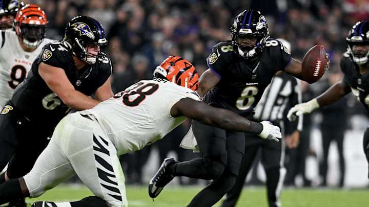 Nov 16, 2023; Baltimore, Maryland, USA; Baltimore Ravens quarterback Lamar Jackson (8) stiff arms Cincinnati Bengals defensive tackle DJ Reader (98) during the third quarter at M&T Bank Stadium. Mandatory Credit: Tommy Gilligan-Imagn Images