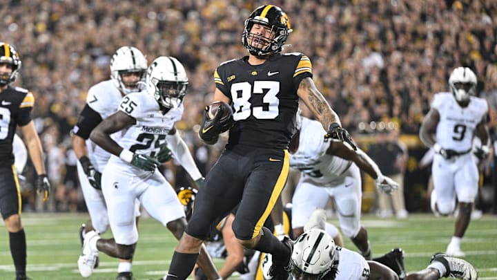 Sep 30, 2023; Iowa City, Iowa, USA; Iowa Hawkeyes tight end Erick All (83) scores on a touchdown pass as Michigan State Spartans running back Jalen Berger (8) attempts to make the tackle during the second quarter at Kinnick Stadium. Mandatory Credit: Jeffrey Becker-Imagn Images