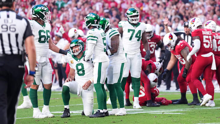 Nov 10, 2024; Glendale, Arizona, USA; New York Jets quarterback Aaron Rodgers (8) is helped up by teammates after turning the ball over against the Arizona Cardinals during the second half at State Farm Stadium.