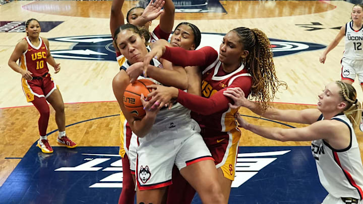 Dec 21, 2024; Hartford, Connecticut, USA; UConn Huskies forward Ice Brady (25) and forward Sarah Strong (21) work for the ball against USC Trojans center Rayah Marshall (13) and forward Kiki Iriafen (44) in the first half at XL Center. Mandatory Credit: David Butler II-Imagn Images