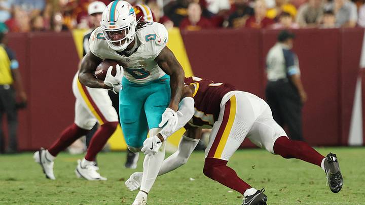 Miami Dolphins running back Ollie Gordon II (0) runs with the ball as Washington Commanders cornerback Car'lin Vigers (37) makes a tackle during the second half at Northwest Stadium. Miami Dolphins running back Ollie Gordon II (0) runs with the ball as Washington Commanders cornerback Car'lin Vigers (37) makes a tackle during the second half at Northwest Stadium.