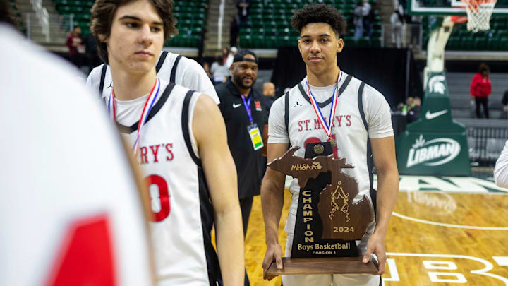 Orchard Lake St. Marys Jayden Savoury (31) holds the MHSAA trophy after defeating North Farmington 63-52 during the MHSAA Div. 1 finals at the Breslin Center in East Lansing on Saturday, March 16, 2024.