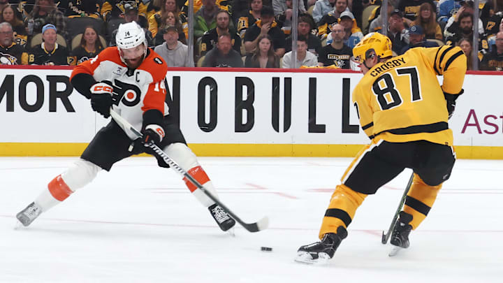 Apr 18, 2026; Pittsburgh, Pennsylvania, USA; Philadelphia Flyers center Sean Couturier (14) moves the puck against Pittsburgh Penguins center Sidney Crosby (87) during the second period in game one of the first round of the 2026 Stanley Cup Playoffs at PPG Paints Arena.