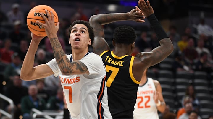 Mar 13, 2025; Indianapolis, IN, USA; Illinois Fighting Illini forward Will Riley (7) scores past Iowa Hawkeyes forward Seydou Traore (7) during the first half at Gainbridge Fieldhouse. Mandatory Credit: Robert Goddin-Imagn Images