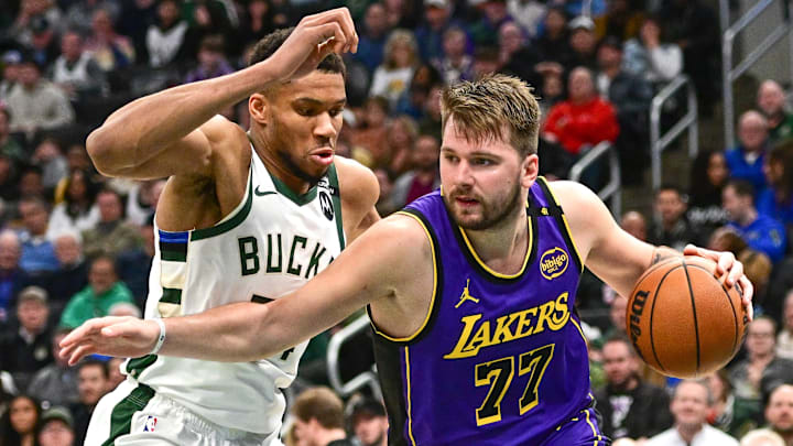 Mar 13, 2025; Milwaukee, Wisconsin, USA;  Los Angeles Lakers guard Luka Doncic (77) drives to the basket against Milwaukee Bucks forward Giannis Antetokounmpo (34) in the third quarter at Fiserv Forum. Mandatory Credit: Benny Sieu-Imagn Images