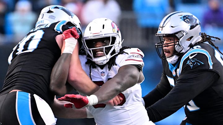 Dec 22, 2024; Charlotte, North Carolina, USA; Arizona Cardinals defensive end Darius Robinson (56) rushes as Carolina Panthers guard Brady Christensen (70) and guard Robert Hunt (50) defend in overtime at Bank of America Stadium. Mandatory Credit: Bob Donnan-Imagn Images Dec 22, 2024; Charlotte, North Carolina, USA; Arizona Cardinals defensive end Darius Robinson (56) rushes as Carolina Panthers guard Brady Christensen (70) and guard Robert Hunt (50) defend in overtime at Bank of America Stadium. Mandatory Credit: Bob Donnan-Imagn Images