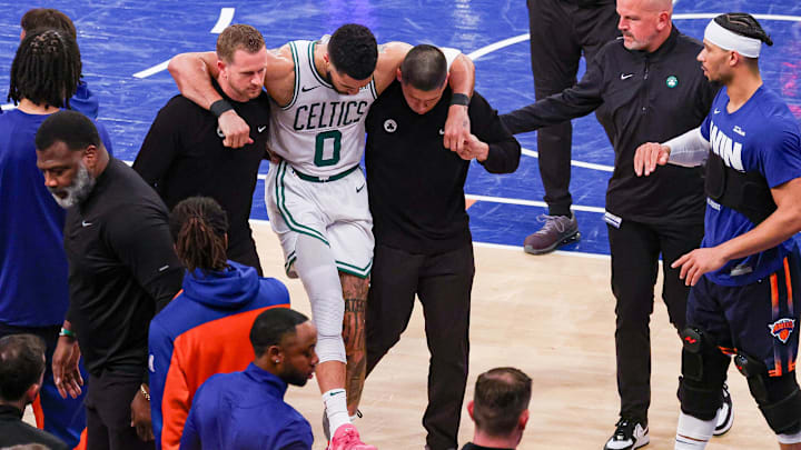May 12, 2025; New York, New York, USA; Boston Celtics forward Jayson Tatum (0) is helped off the court by after an injury in the second half during game four of the second round for the 2025 NBA Playoffs against the New York Knicks at Madison Square Garden. Tatum would leave the game with an injury after this play. Mandatory Credit: Vincent Carchietta-Imagn Images May 12, 2025; New York, New York, USA; Boston Celtics forward Jayson Tatum (0) is helped off the court by after an injury in the second half during game four of the second round for the 2025 NBA Playoffs against the New York Knicks at Madison Square Garden. Tatum would leave the game with an injury after this play. Mandatory Credit: Vincent Carchietta-Imagn Images