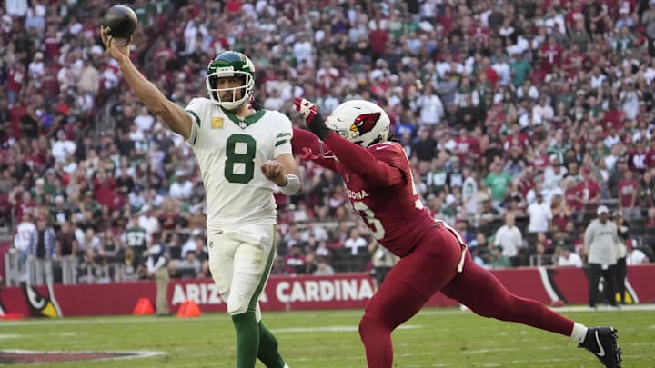 New York Jets quarterback Aaron Rodgers (8) throws while pressured by Arizona Cardinals linebacker Baron Browning (53) during the first quarter at State Farm Stadium on Nov 10, 2024, in Glendale.