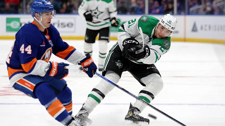 Feb 23, 2025; Elmont, New York, USA; Dallas Stars left wing Jason Robertson (21) plays the puck ahead against New York Islanders center Jean-Gabriel Pageau (44) during the third period at UBS Arena. Mandatory Credit: Brad Penner-Imagn Images