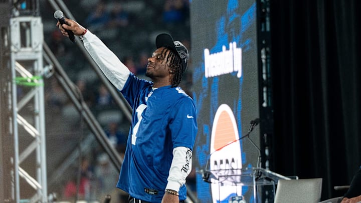 Malik Nabers raises his mic in the air during Giants Fan Fest at MetLife Stadium to celebrate 100 Seasons of the New York Giants, Friday, Sept. 6, 2024.