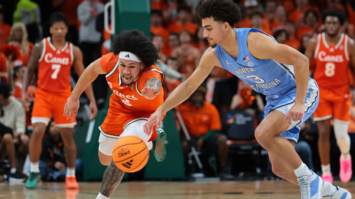 Feb 10, 2026; Coral Gables, Florida, USA; Miami Hurricanes guard Tre Donaldson (3) and North Carolina Tar Heels guard Derek Dixon (3) reach for a loose ball during the first half at Watsco Center. Mandatory Credit: Sam Navarro-Imagn Images