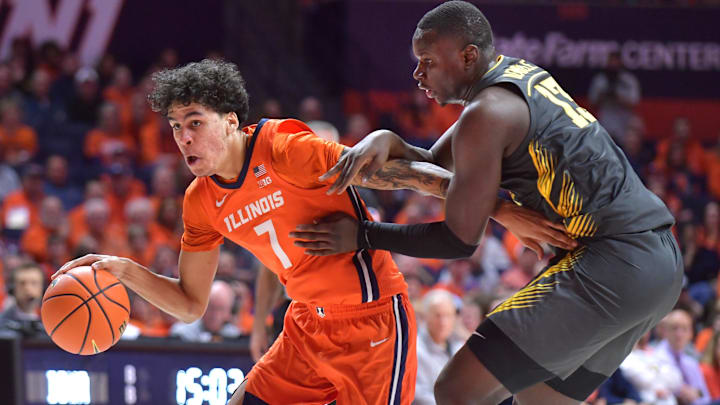 Feb 25, 2025; Champaign, Illinois, USA;  Illinois Fighting Illini forward Will Riley (7) drives the ball past Iowa Hawkeyes forward Ladji Dembele (13) during the
first half at State Farm Center. Mandatory Credit: Ron Johnson-Imagn Images