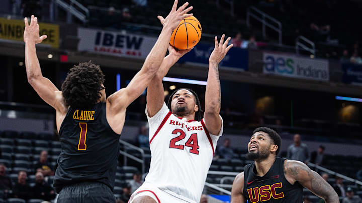 In a battle of future UW teammates, Rutgers big man Lathan Sommerville (24) shoots over USC's Desmond Claude (1).