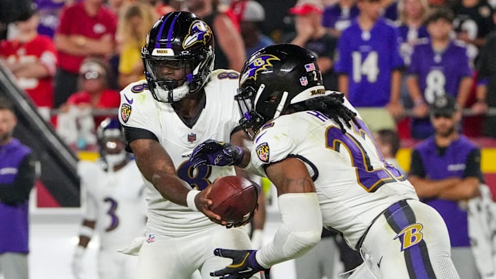 Baltimore Ravens quarterback Lamar Jackson hands off to running back Derrick Henry.