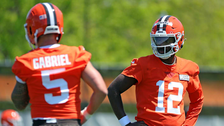 Cleveland Browns quarterback Shedeur Sanders (12) watches quarterback Dillon Gabriel (5) during day two of NFL rookie minicamp at the Cleveland Browns training facility on Saturday, May 10, 2025, in Berea, Ohio.