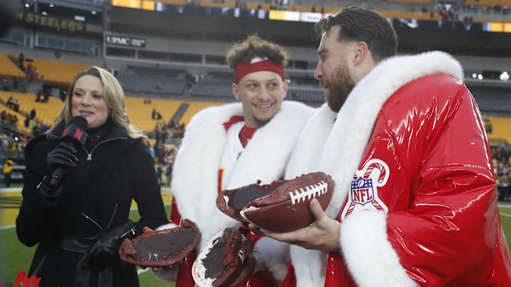 Dec 25, 2024; Pittsburgh, Pennsylvania, USA;  Kansas City Chiefs quarterback Patrick Mahomes (middle) and tight end Travis Kelce (right) open their Netflix Christmas GameDay cake after the Chiefs defeated the Pittsburgh Steelers at Acrisure Stadium. Mandatory Credit: Charles LeClaire-Imagn Images