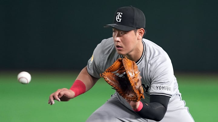 Mar 15, 2025; Bunkyo, Tokyo, Japan; Yomiuri Giants first baseman Kazuma Okamoto (25) fields a ground ball against the Los Angeles Dodgers during the fifth inning at Tokyo Dome. Mandatory Credit: Darren Yamashita-Imagn Images