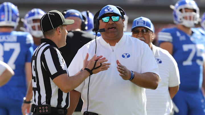 Nov 8, 2025; Lubbock, Texas, USA;  Brigham Young Cougars head coach Kalani Sitake discusses a call with Big 12 official Randy Smith in the second half of the game against the Texas Tech Red Raiders at Jones AT&T Stadium. Mandatory Credit: Michael C. Johnson-Imagn Images