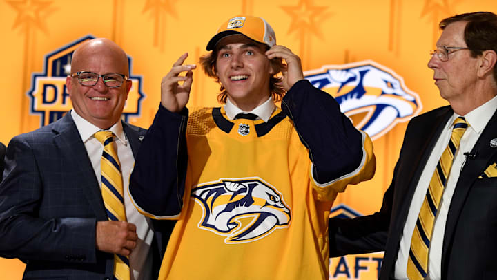Jun 28, 2023; Nashville, Tennessee, USA; Nashville Predators draft pick Tanner Molendyk puts on a hat after being selected with the twenty fourth pick in round one of the 2023 NHL Draft at Bridgestone Arena. Mandatory Credit: Christopher Hanewinckel-Imagn Images