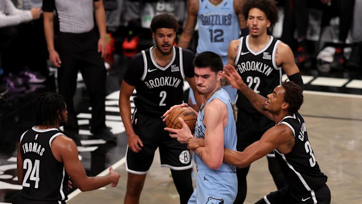 Nov 4, 2024; Brooklyn, New York, USA; Memphis Grizzlies center Zach Edey (14) fights for the ball against Brooklyn Nets center Nic Claxton (33) and guard Cam Thomas (24) and forwards Cameron Johnson (2) and Jalen Wilson (22) during the first quarter at Barclays Center. Mandatory Credit: Brad Penner-Imagn Images