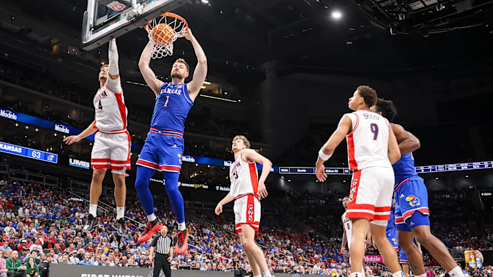 Mar 13, 2025; Kansas City, MO, USA; Kansas Jayhawks center Hunter Dickinson (1) dunks around Arizona Wildcats forward Trey Townsend (4) during the second half at T-Mobile Center. Mandatory Credit: William Purnell-Imagn Images