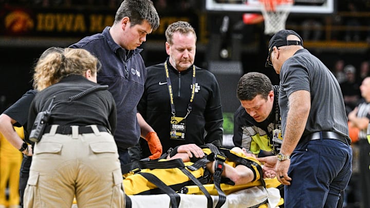 Iowa cheerleader Austin Beam is attended to by team trainers and paramedics after being injured during the game between Iowa and Minnesota at Carver-Hawkeye Arena in Iowa City, Iowa, on Jan. 21, 2025. Beam fell while performing during a time out. Iowa cheerleader Austin Beam is attended to by team trainers and paramedics after being injured during the game between Iowa and Minnesota at Carver-Hawkeye Arena in Iowa City, Iowa, on Jan. 21, 2025. Beam fell while performing during a time out.