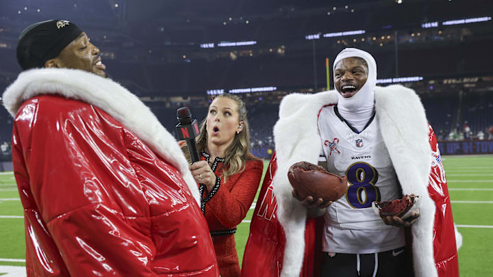 Dec 25, 2024; Houston, Texas, USA;  Baltimore Ravens quarterback Lamar Jackson (8) and running back Derrick Henry (22) wear Santa coats while being interviewed by Netflix host Jamie Erdahl after the game against the Houston Texans at NRG Stadium. Mandatory Credit: Troy Taormina-Imagn Images