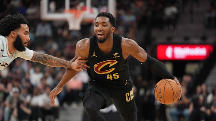 Apr 4, 2025; San Antonio, Texas, USA;  Cleveland Cavaliers guard Donovan Mitchell (45) dribbles against San Antonio Spurs forward Julian Champagnie (30) in the first half at Frost Bank Center. Mandatory Credit: Daniel Dunn-Imagn Images