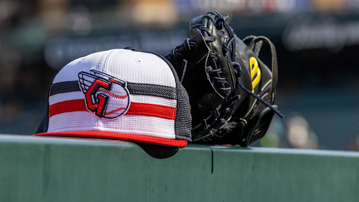 Jul 8, 2024; Detroit, Michigan, USA; A Cleveland Guardians baseball cap and glove sit on the dugout rail before the game against the Detroit Tigers at Comerica Park. Mandatory Credit: David Reginek-Imagn Images