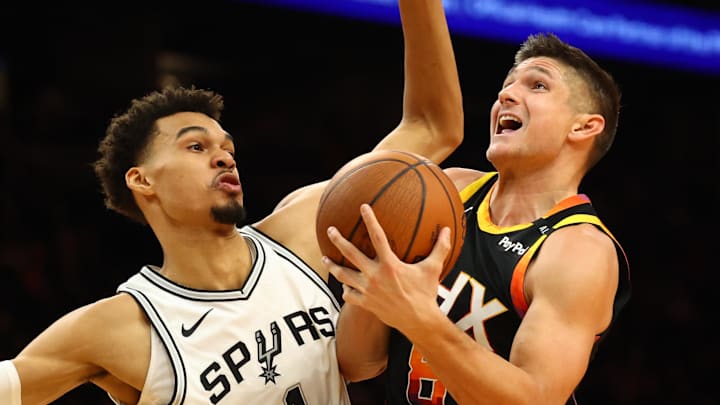 Dec 3, 2024; Phoenix, Arizona, USA; San Antonio Spurs center Victor Wembanyama (1) defends against Phoenix Suns guard Grayson Allen (8) in the second half of an NBA Cup game at Footprint Center. Mandatory Credit: Mark J. Rebilas-Imagn Images