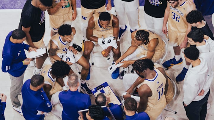 The Huskies huddle during a timeout. The Huskies huddle during a timeout.
