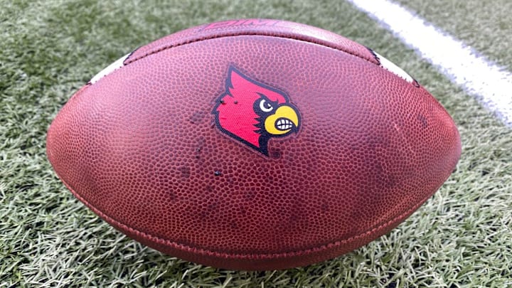A football sporting the Louisville Cardinals logo A football sporting the Louisville Cardinals logo