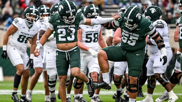 Michigan State's Kenny Soares Jr., left, and Ben Roberts clean the dirt off their cleats during the football Spring Showcase on Saturday, April 18, 2026, at Spartan Stadium in East Lansing.