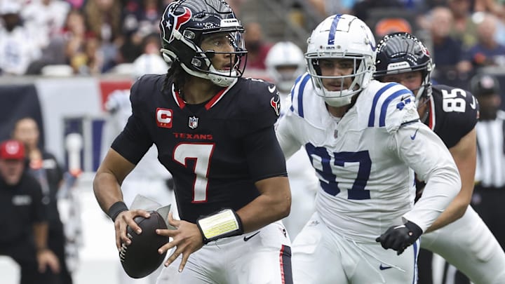 Oct 27, 2024; Houston, Texas, USA; Houston Texans quarterback C.J. Stroud (7) looks for an open receiver as Indianapolis Colts defensive end Laiatu Latu (97) applies defensive pressure during the game at NRG Stadium. Mandatory Credit: Troy Taormina-Imagn Images
